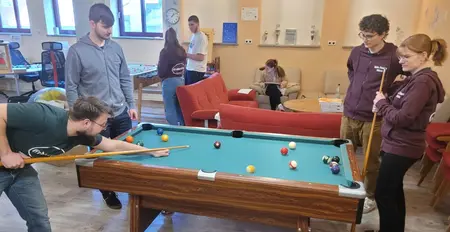 im Jugendcafe spielen 4 Jugendliche am Billard