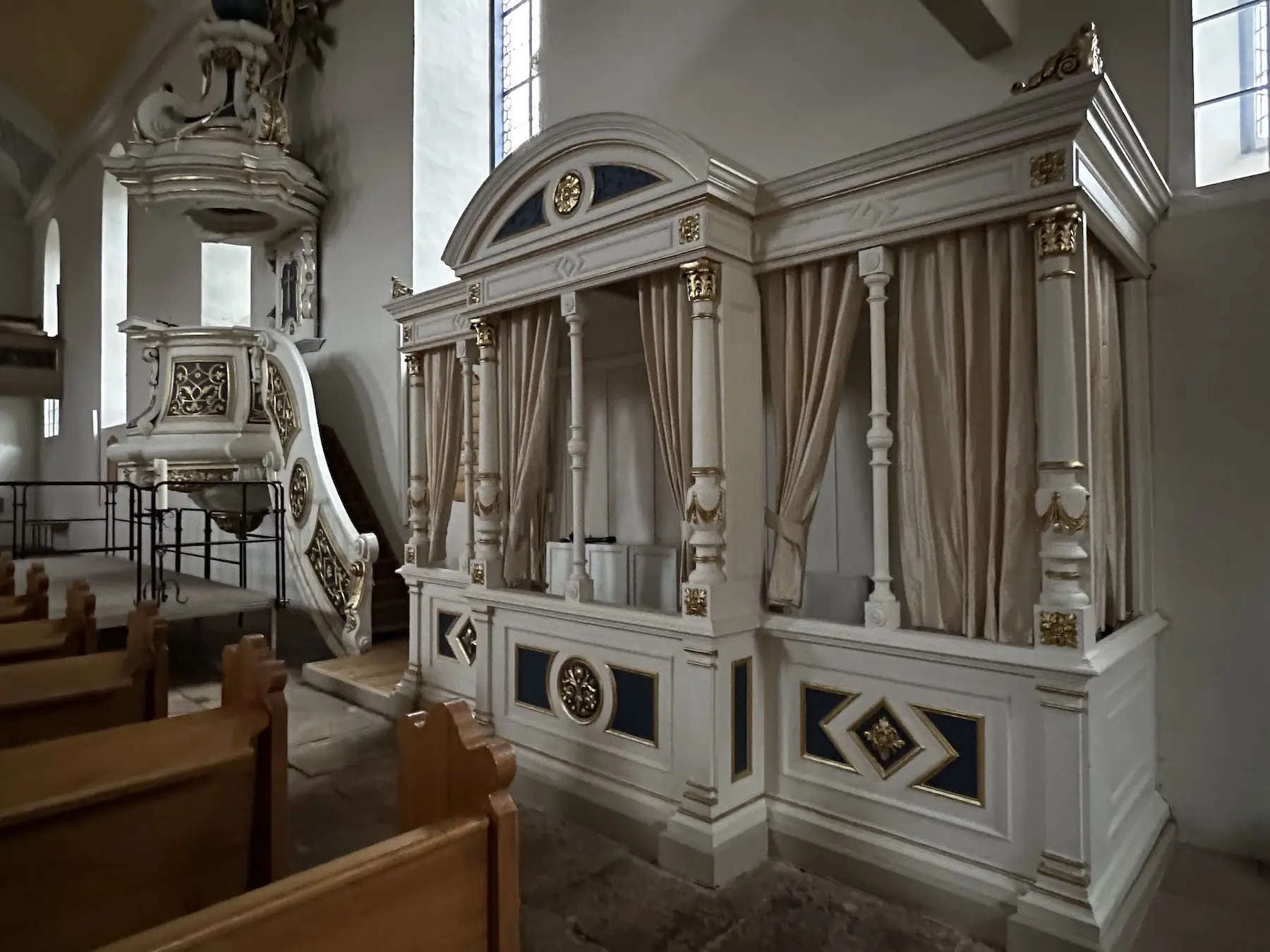 Der Pfarrstuhl (rechts neben der Kanzel), in welchem der Pfarrer saß, wenn er nicht predigte oder liturgisch tätig war, gleicht eher einer Fürstenloge. Er stammt aus dem Jahr 1876.